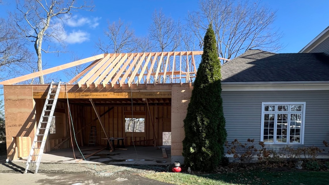 extension garage under construction with exposed wooden roof framing