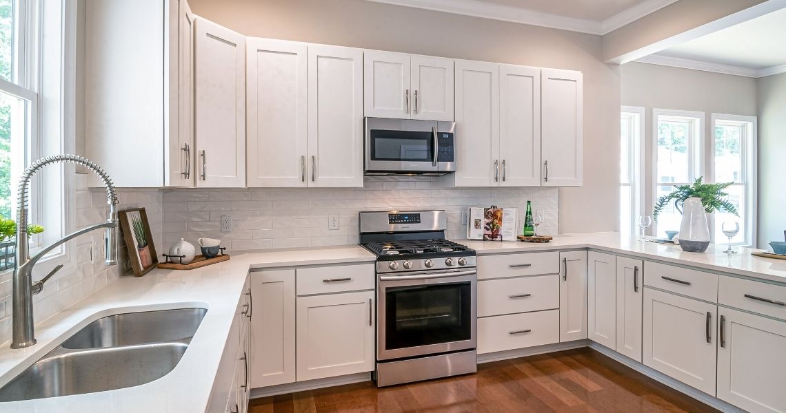 A bright modern kitchen featuring white shaker-style cabinets