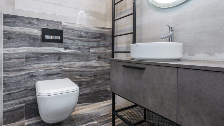 Sleek modern bathroom with gray tiles and minimalist design, ideal for a half bath remodel.