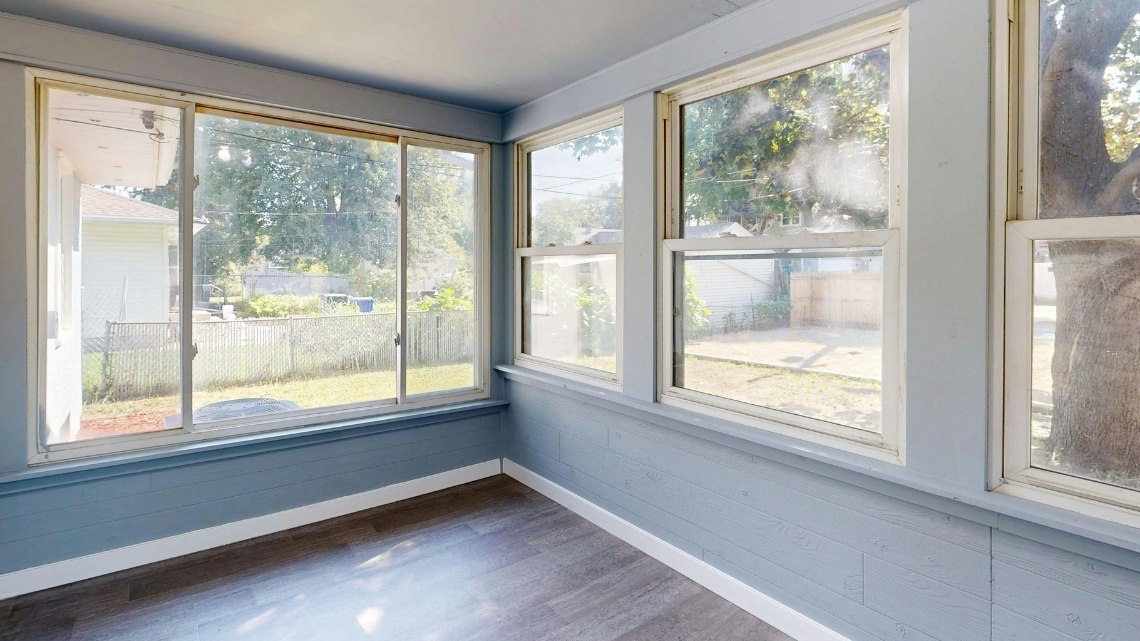 enclosed sunroom or porch featuring grey-painted wood-plank walls